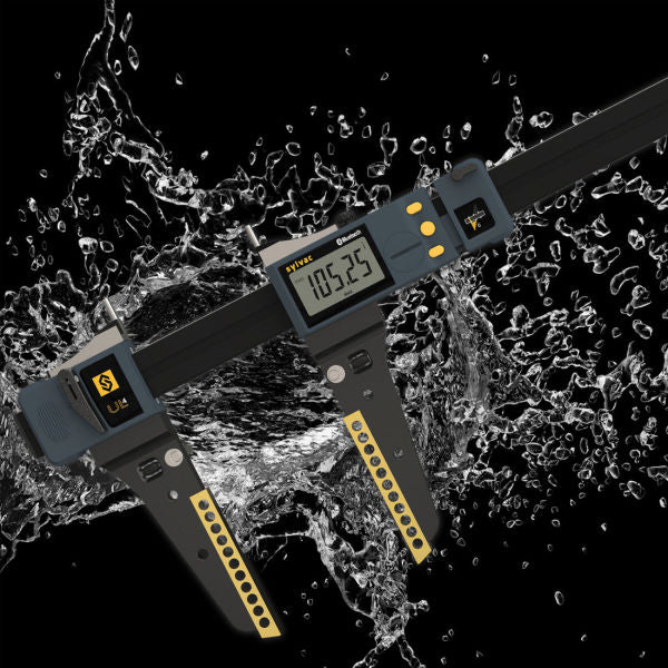 A digital caliper measuring device with a dark gray body, yellow accents, and a display screen, shown diagonally through a dynamic water splash on a black background.